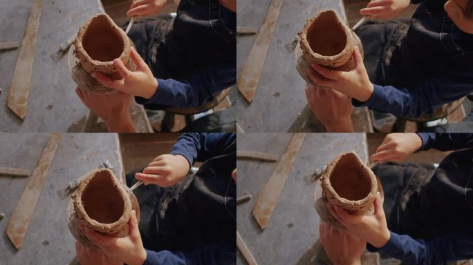 一个雕塑家男孩在他的轮子上，在他的舞台上工作，用手把粘土做成碗，他的手艺是传统与创造力之间的桥梁