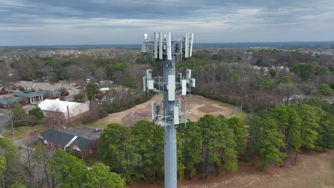 美国城镇郊区的电信塔。蜂窝网络天线向邻居发送信号波。空中近距离轨道。