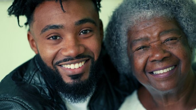 ▽幸福的时代对比= 80多岁的老奶奶和20多岁的儿子对着镜头微笑的特写