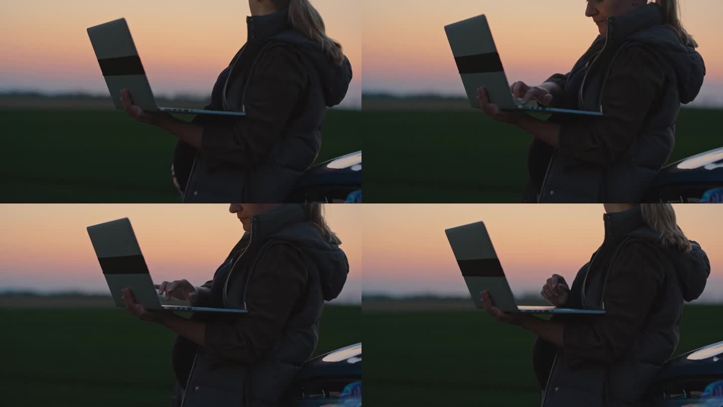 SLO - MO孕妇在日落时分在农田里开车时使用笔记本电脑