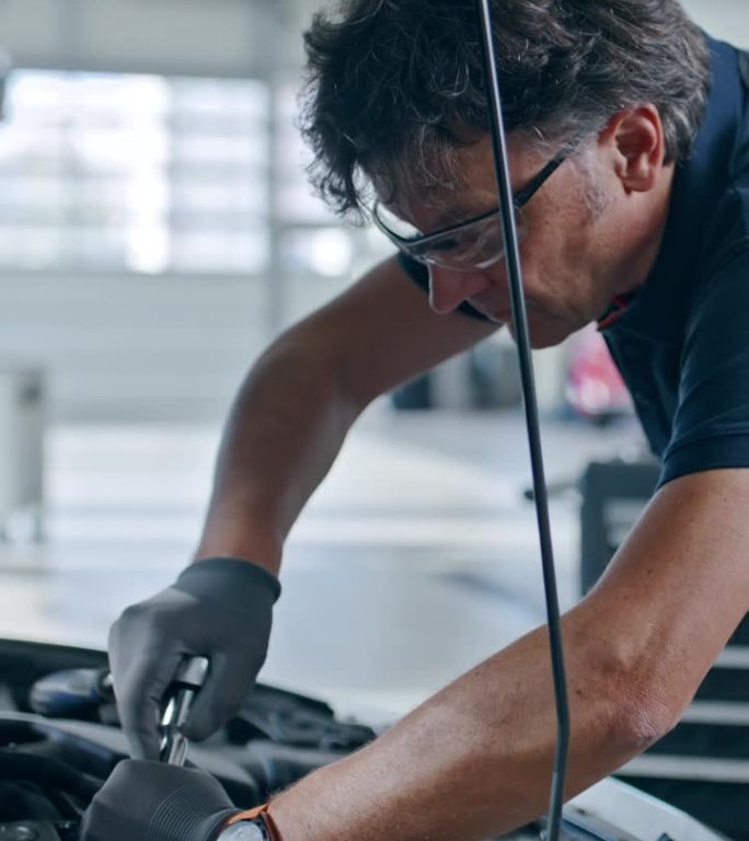 男机械师在汽车修理店修理汽车发动机