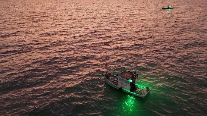 鱿鱼渔船在日落后打开鱿鱼诱饵灯。渔船出海捕鱼，泰国一整夜。渔船的俯视图