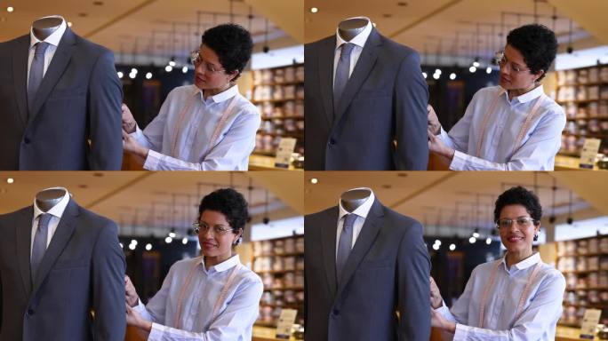 一名女裁缝在一家男装精品店调整西装，然后面对镜头微笑的视频肖像