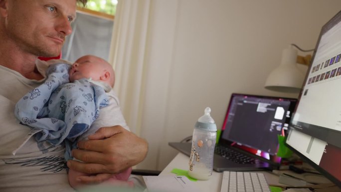 SLO MO的喜悦在工作和父亲的和谐融合期间锁定与慢动作拍摄，以一个快乐和慈爱的父亲使用台式电脑，同