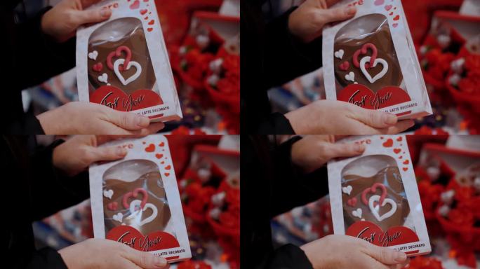 情人节特价。特写镜头。小盒子里装着心形的巧克力姜饼，拿在手里。情人节的礼物，作为感情和爱的表达。在超
