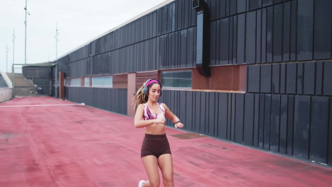 年轻的女运动员在户外跑步后看她的智能手表上的心率。