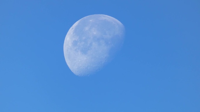 蓝蓝的天空上，月亏时的月亮特写
