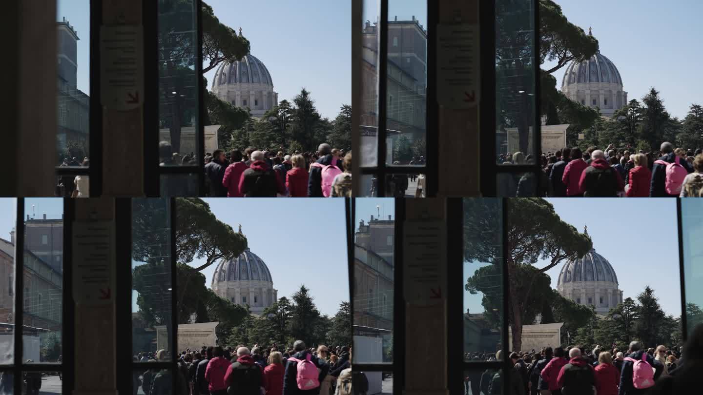 在意大利罗马的梵蒂冈，一群游客在皮纳科特卡博物馆的庭院里观赏令人惊叹的圣彼得大教堂圆顶