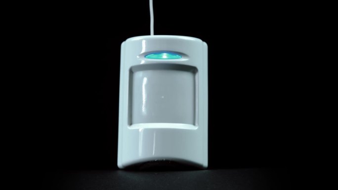 报警系统包括白色塑料运动传感器，其中有一个闪烁的蓝色LED
