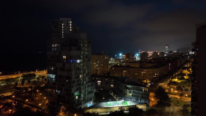 夜间照明巴塞罗那市海滩湾公寓大楼航拍全景4k西班牙