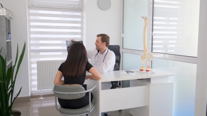 女病人在脊椎病学中心的理疗师那里检查脊柱。椎体学的概念。