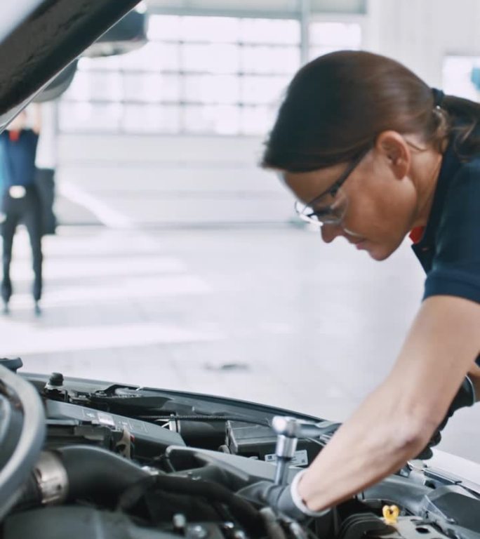 女机械师在汽车修理店修理汽车发动机