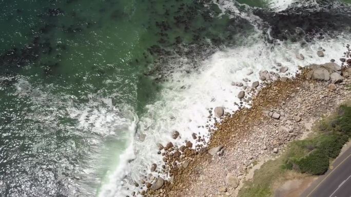 在南非开普敦的十二使徒山，泡沫般的海浪溅起岩石海岸。空中拍摄