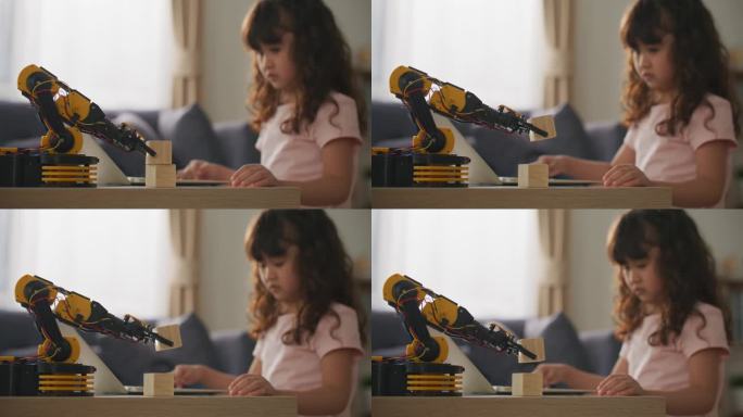 亚洲女孩用笔记本电脑学习控制机械臂