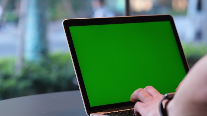 使用绿色屏幕的笔记本电脑的特写