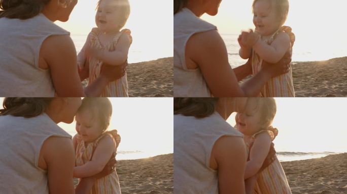夏日夕阳下，一家人在海滩度假，母亲亲吻她的女婴