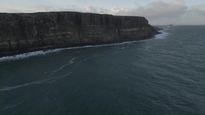 鸟瞰图，苏格兰天空中崎岖的苏格兰裙岩悬崖，海浪拍打着海岸