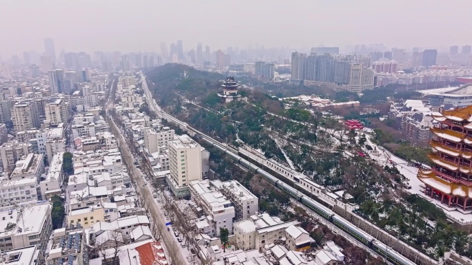大雪下通过武汉黄鹤楼的客运列车