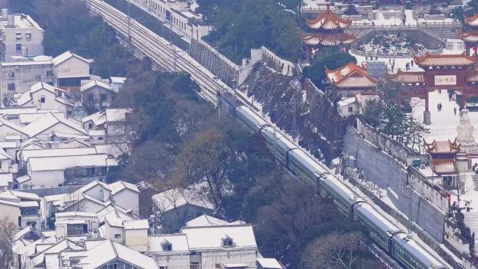 大雪下通过武汉黄鹤楼的客运列车