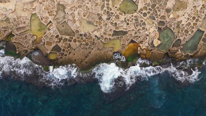 从空中俯瞰马耳他岛海岸的盐田。飞越马耳他的石板田