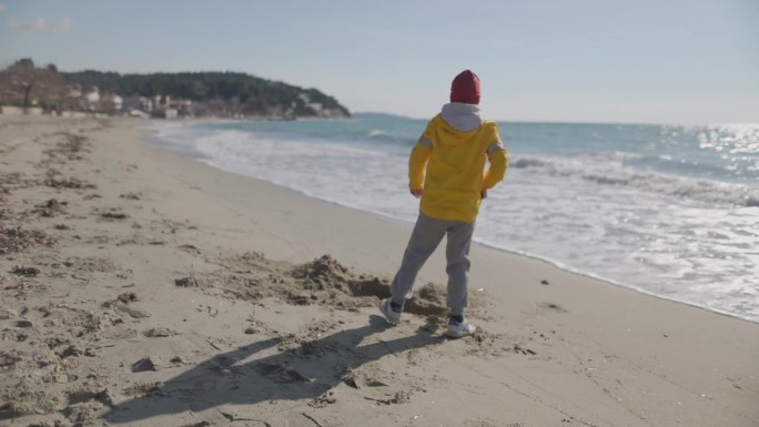 寒假期间在沙滩上玩铲子的快乐男孩