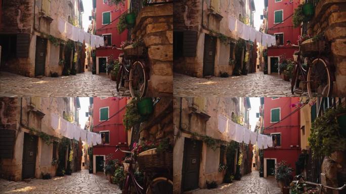 老城区鹅卵石小径上的自行车和挂着晾衣绳的植物的慢镜头镜头。罗维尼，伊斯特拉，克罗地亚。