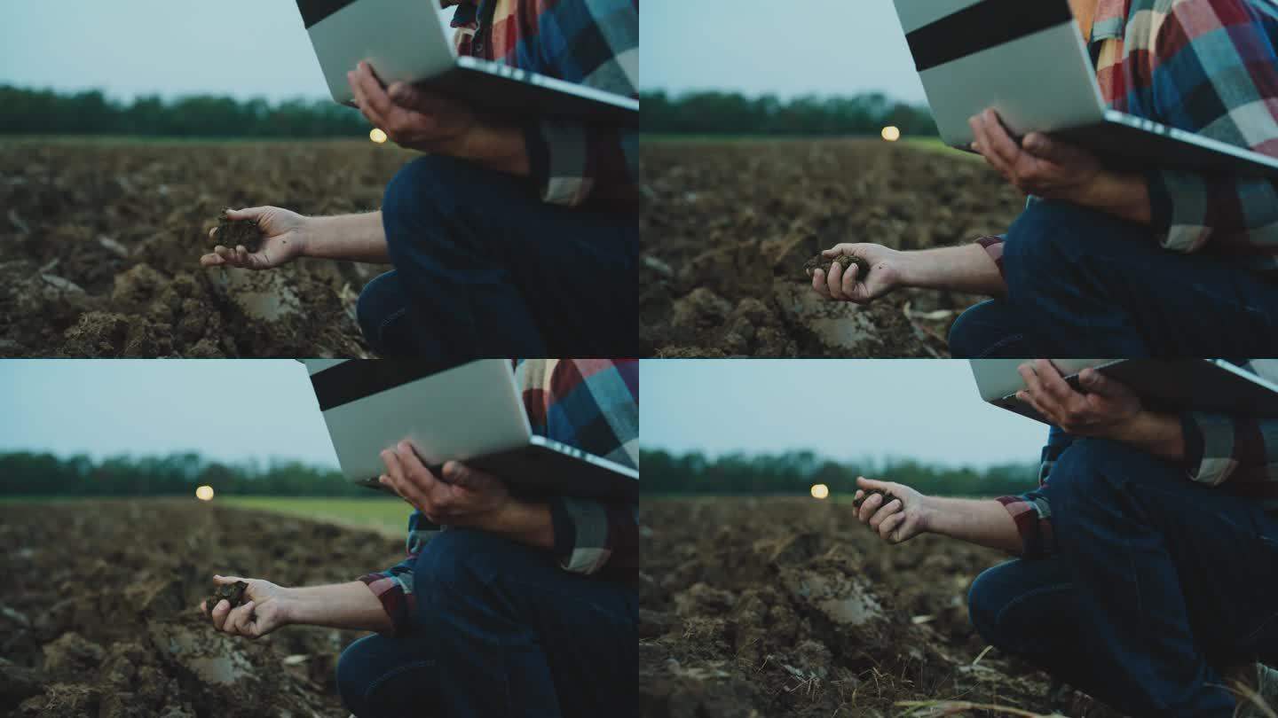 在黄昏时分，农学家用手提电脑分析犁地的土壤。