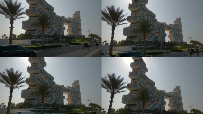 阳光明媚的一天迪拜城棕榈岛著名的新现代豪华酒店外部交通街道慢动作全景4k阿联酋