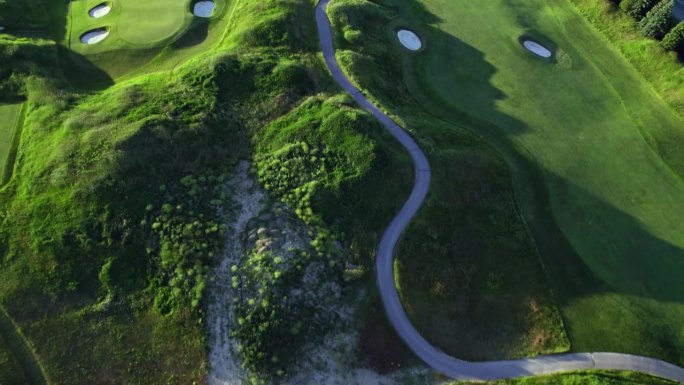 高尔夫球场鸟瞰图。高尔夫球杆上方的草木照片。夏日日落的黄金时间，有长长的影子。