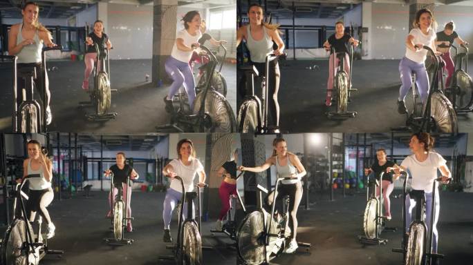 年轻的白人女运动员，在健身房的固定自行车机上一起锻炼
