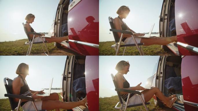 女自由职业者坐在野营车外的椅子上用笔记本电脑工作