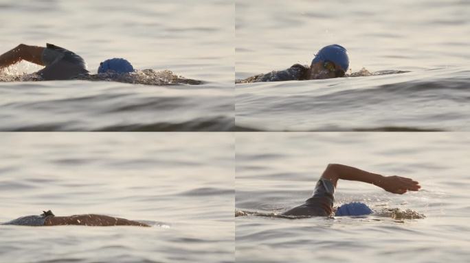 日落时在海洋中游泳的活跃女性的慢镜头镜头。一个女人正在海里游泳。