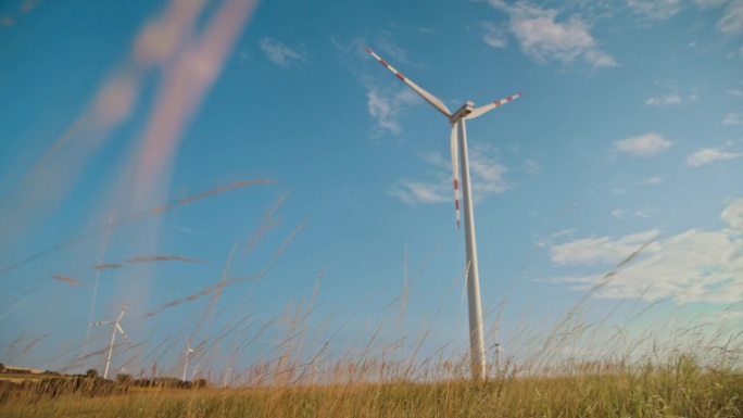 SLO MO草原巨人:风力涡轮机在蔚蓝的天空下升起