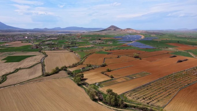 无人机拍摄的农田和太阳能发电厂背景。可持续的资源和生活方式