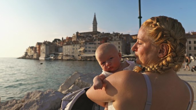 阳光明媚的一天，母亲带着蹒跚学步的孩子在海边度假。罗维尼，伊斯特拉，克罗地亚。