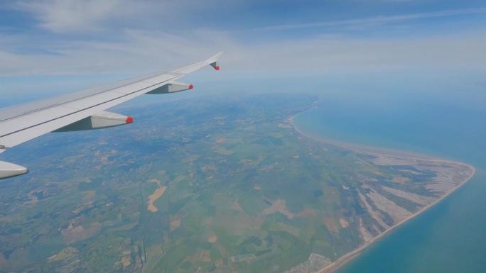 视角:飞行中透过飞机窗户看到的迷人的英国海岸线