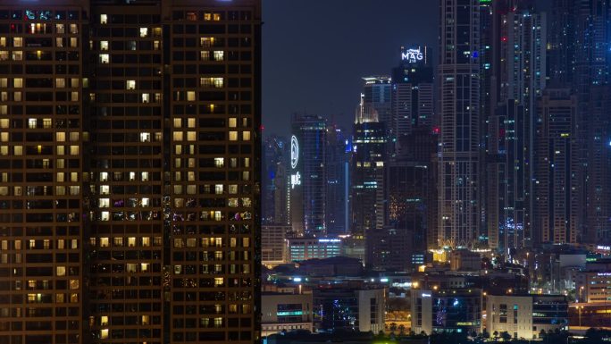 夜间迪拜市中心摩天大楼住宅前屋顶全景4k延时阿联酋