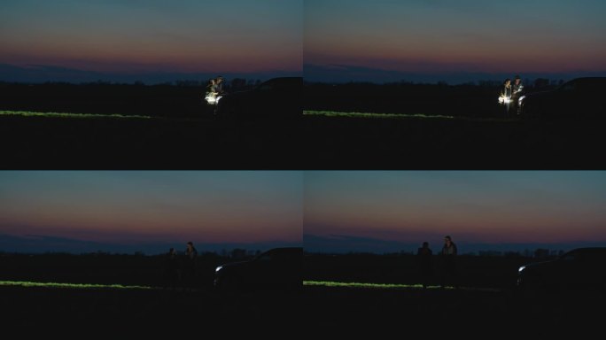 SLO MO锁定拍摄的女性和男性农学家与笔记本电脑走在田野在黄昏的天空
