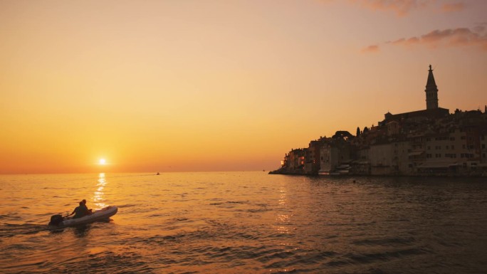 SLO拍摄的游客在船上探索大海在夕阳的天空在假期。罗维尼，伊斯特拉，克罗地亚。