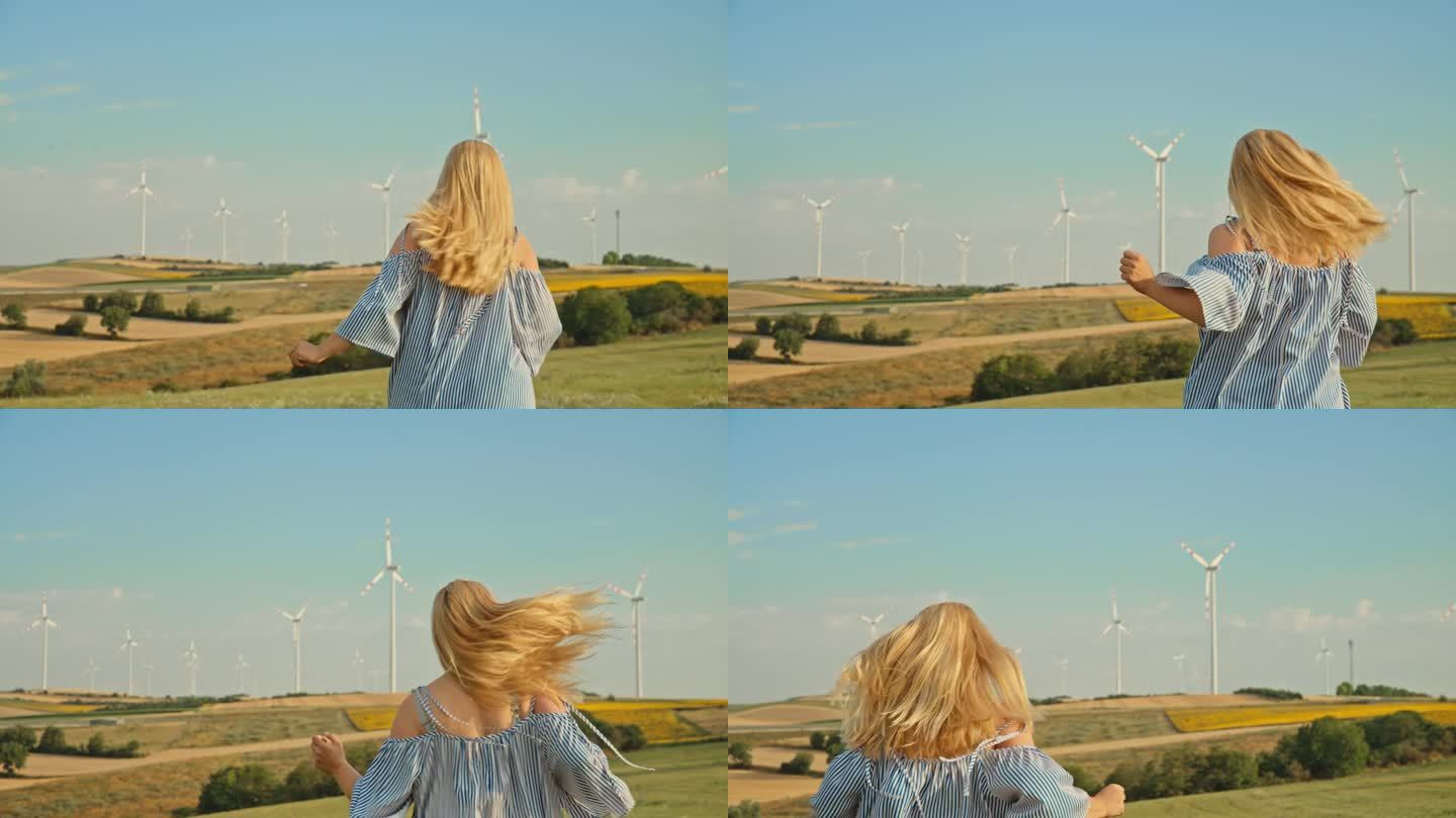 SLO MO追逐明天:女人快乐地奔向风力涡轮机