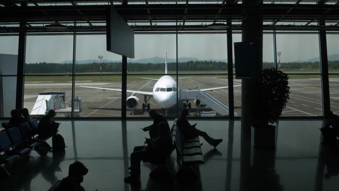 剪影:无法辨认的人在机场等待他们的起飞航班