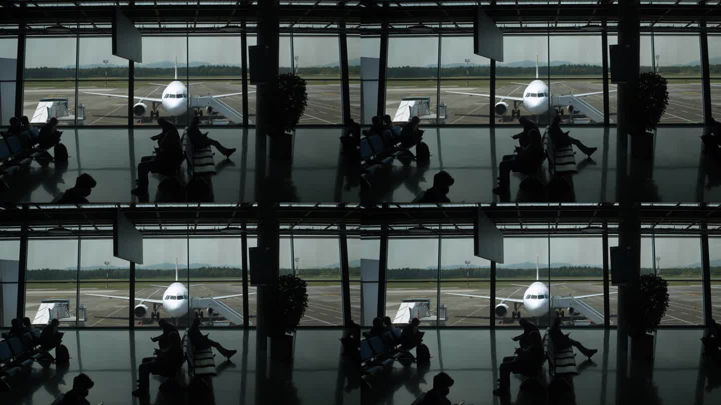 剪影:无法辨认的人在机场等待他们的起飞航班