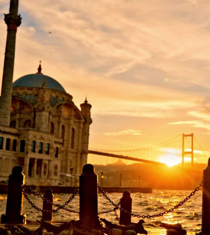 Ortakoy雄伟清真寺的SLO MO日落宁静:鸽子从伊斯坦布尔的海滨长廊翱翔到Ortakoy雄伟的