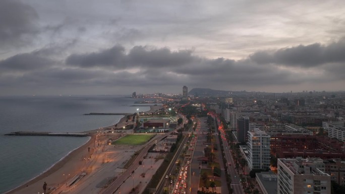 日落时间照明巴塞罗那市海滩湾交通街道道路航拍全景4k西班牙