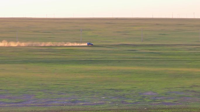 草原上行驶扬起尘土的越野车