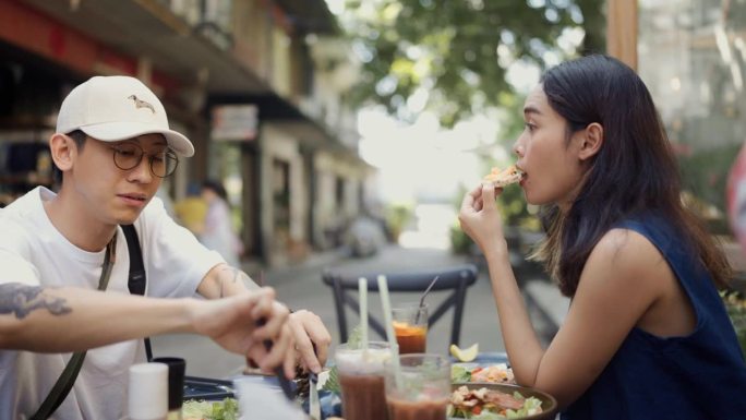 一对亚洲游客夫妇在城里一家美味的餐厅用餐。