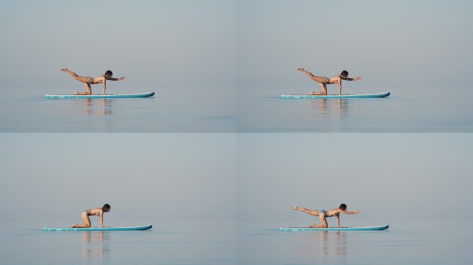 在阳光明媚的日子里，柔韧的比基尼女子在海洋的冲浪板上练习瑜伽
