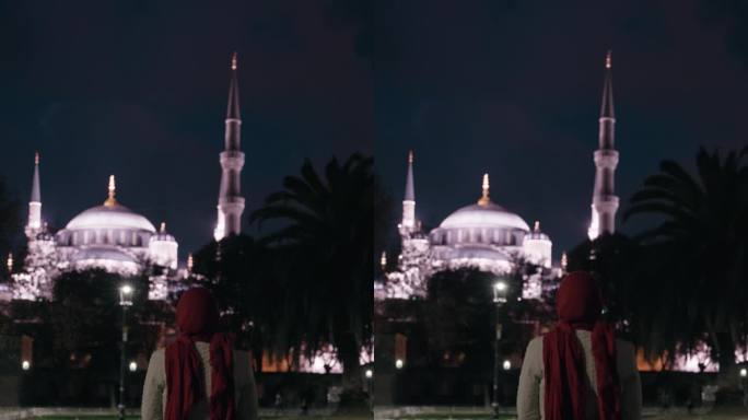 宁静之夜:穆斯林妇女在灯火辉煌的广场上沉思圣索菲亚大教堂的雄伟之美#圣索菲亚之夜#宁静反思#城市之光