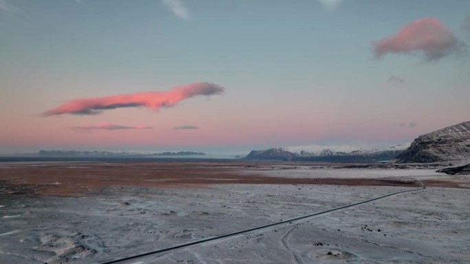 冰岛南部Oraefi，冬季雪景上的粉色日出。无人机回射