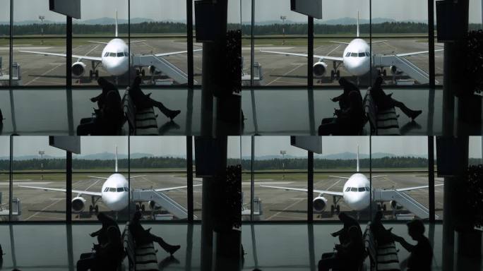 剪影:乘客在等飞机时浏览手机